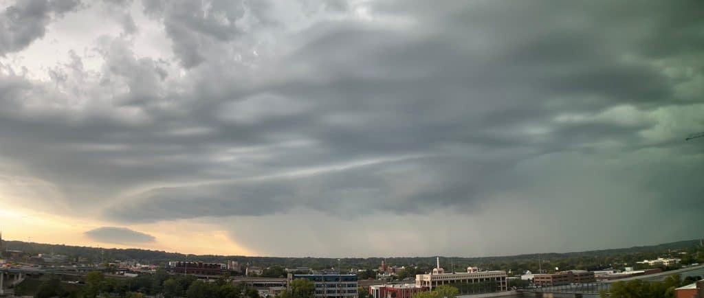 Dark storm clouds gathering over a city skyline, representing an outage that takes down internet and business phones